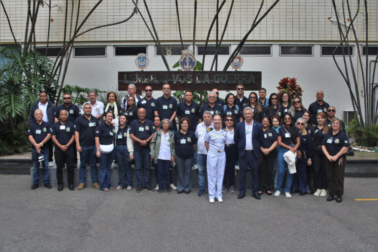 Grupo de pessoas em frente a prédio institucional.
