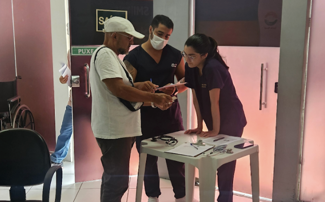 Equipe médica atendendo paciente em clínica.