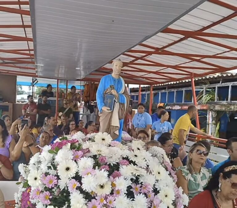 Processão com estátua religiosa e flores