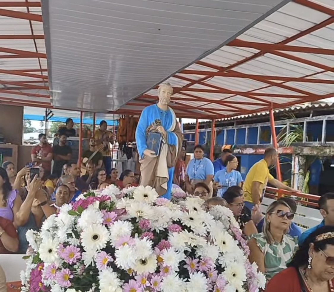 Processão com estátua religiosa e flores