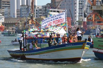 Barco colorido em procissão marítima festiva.