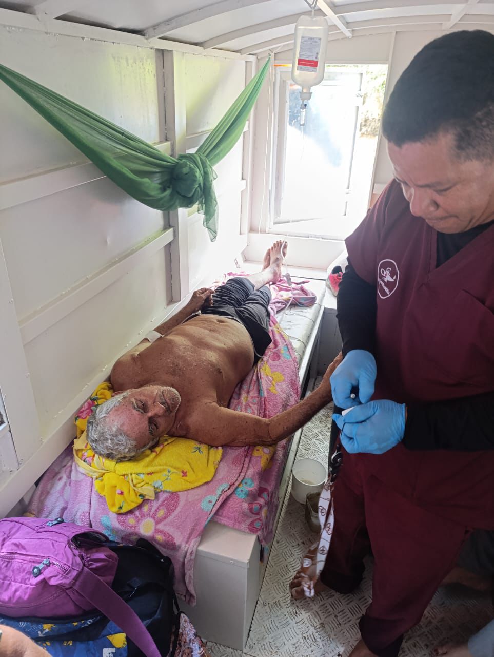 Médico cuidando de paciente em maca improvisada.