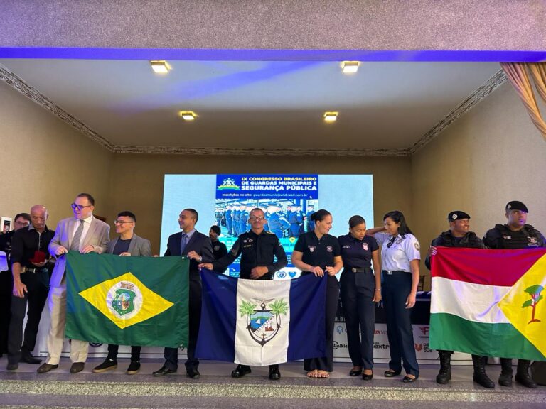 Pessoas segurando bandeiras em evento de segurança pública.