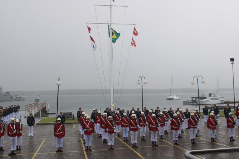 Desfile militar em frente ao mar, bandeira brasileira.
