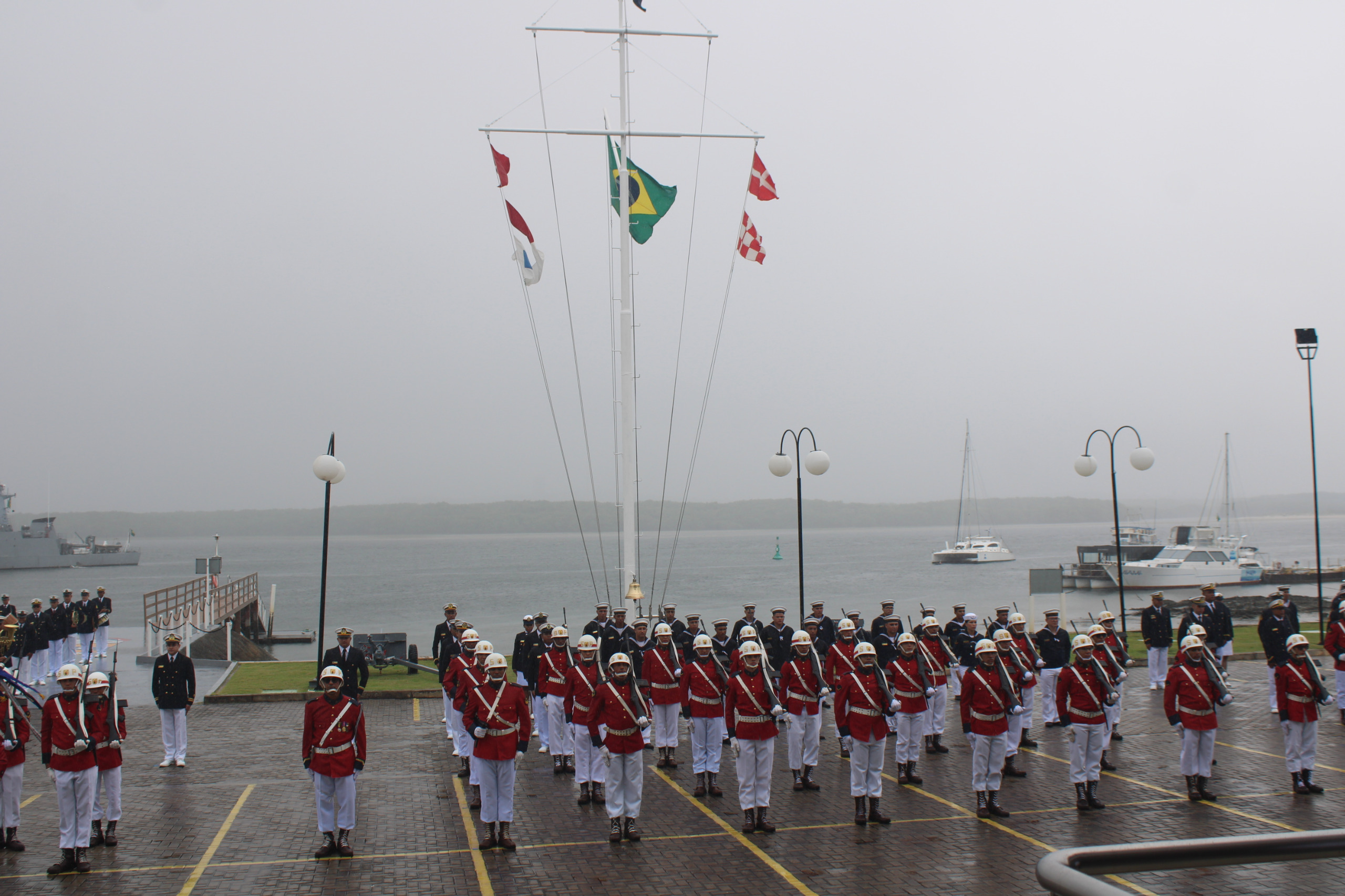 Desfile militar em frente ao mar, bandeira brasileira.