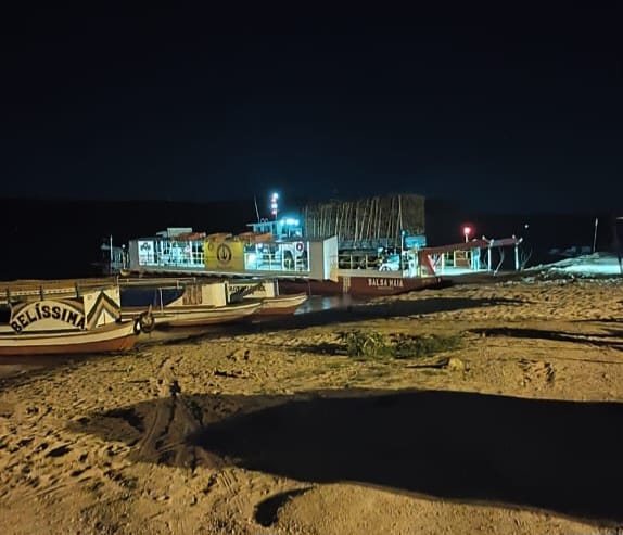 Barcos atracados na praia à noite.