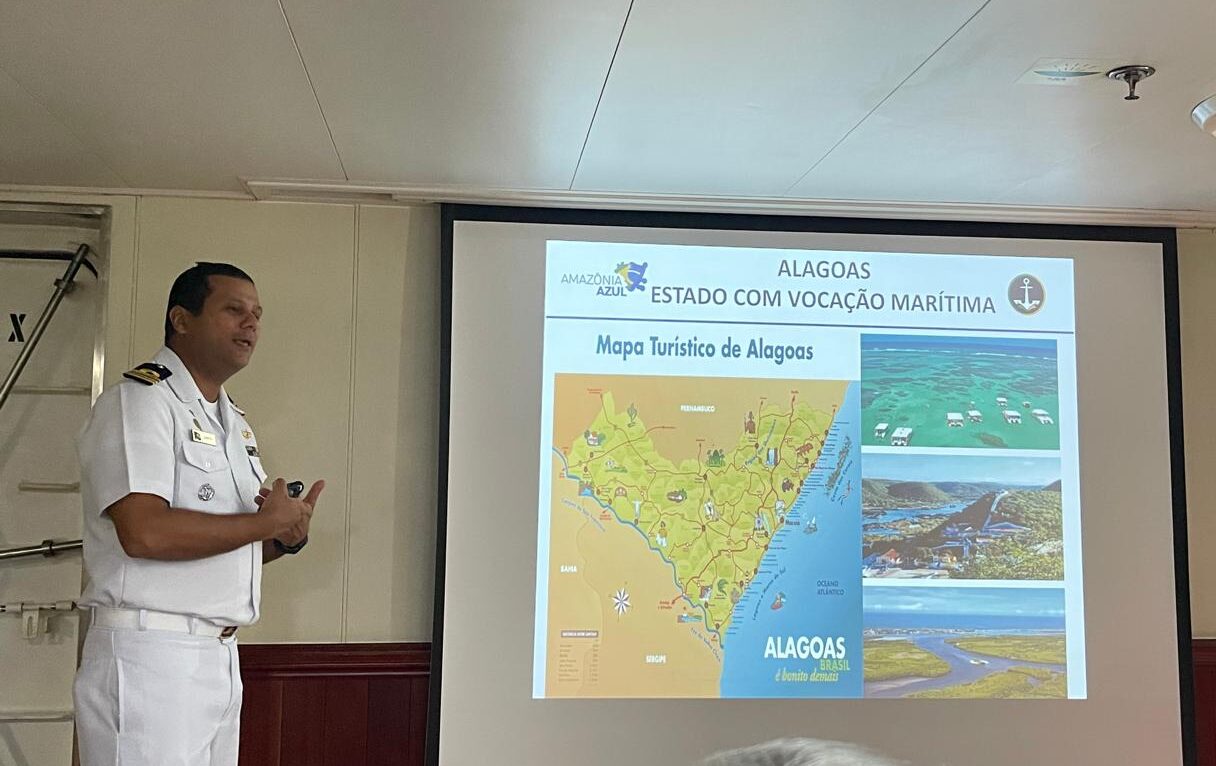 Palestrante mostra mapa turístico de Alagoas.