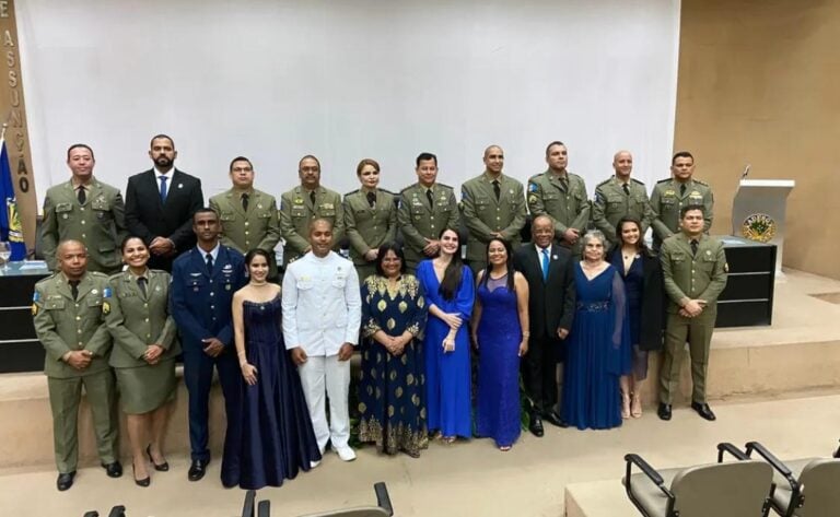 Grupo de pessoas em uniforme e vestidos formais.