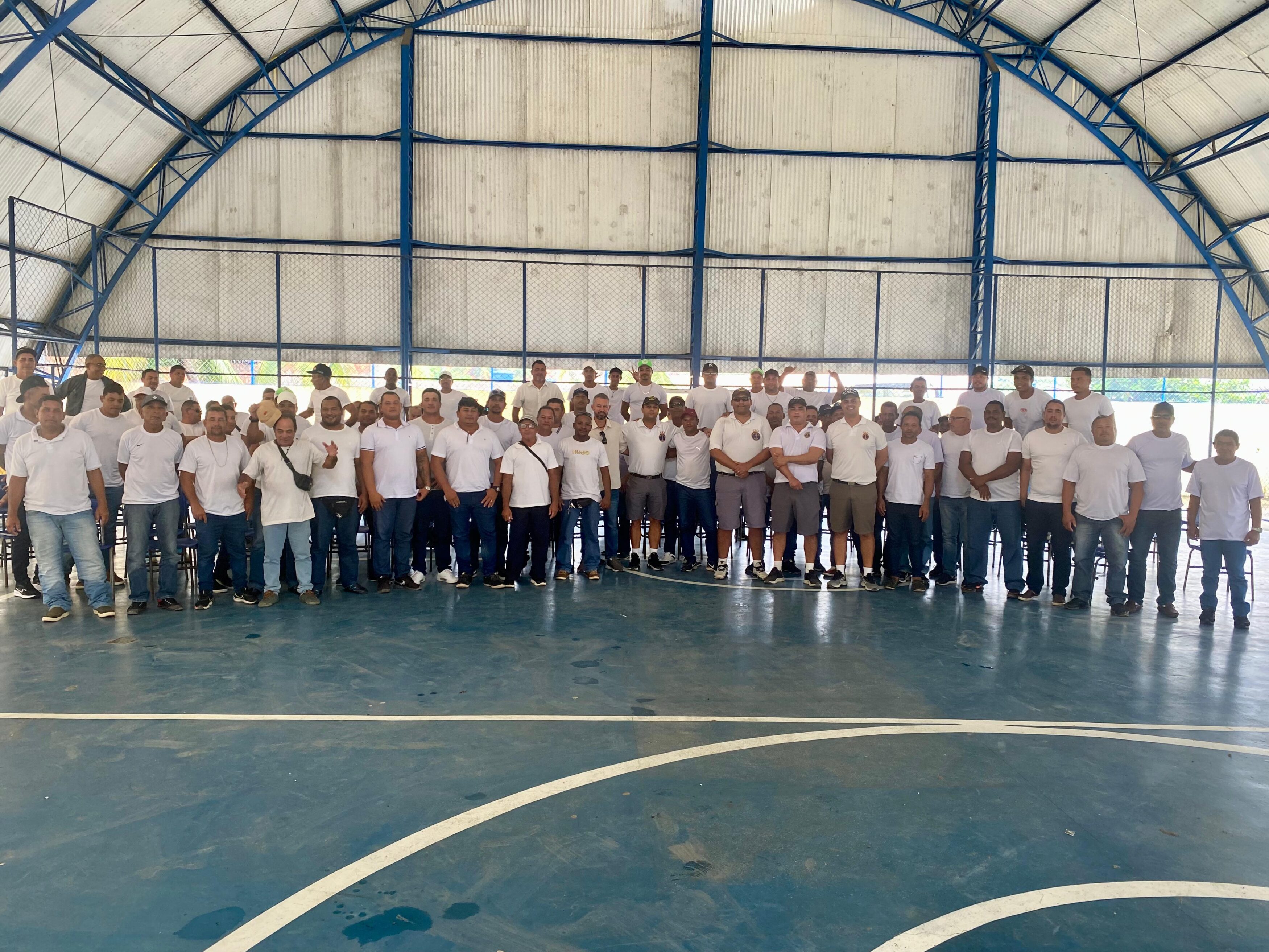 Grupo de pessoas em quadra coberta.