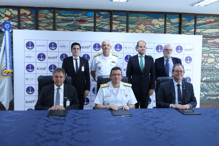 Oficiais e executivos em cerimônia de assinatura.