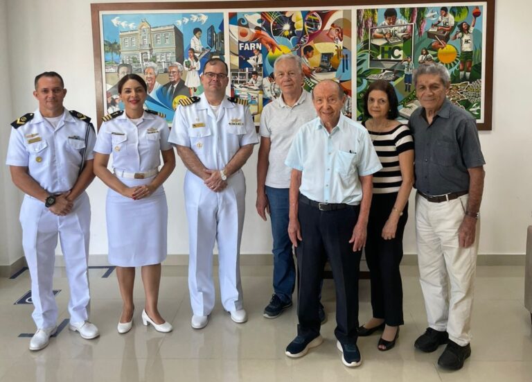 Grupo de pessoas uniformizadas e civis em galeria.