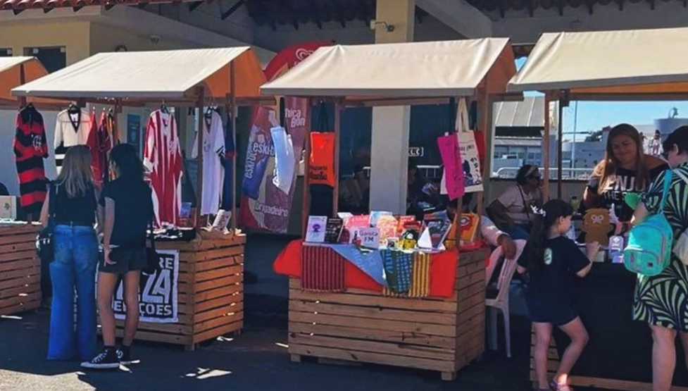 Bancas de feira vendendo roupas e itens diversos.