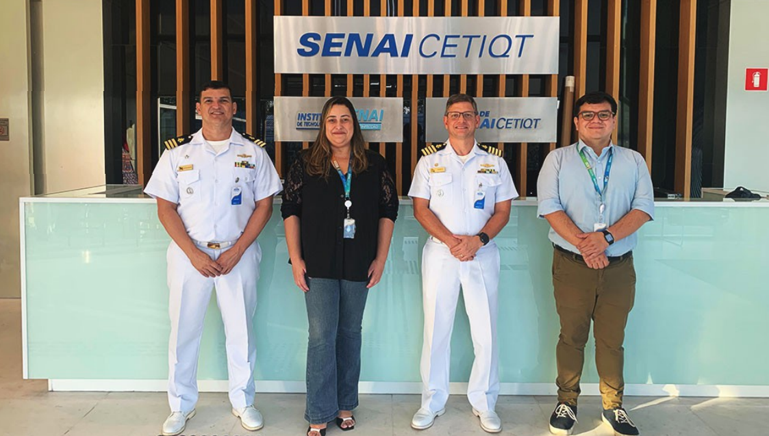 Pessoas em frente ao banner do SENAI CETIQT.