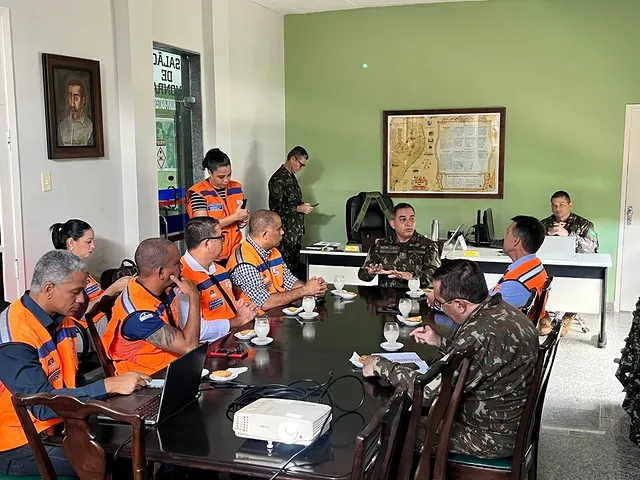 Reunião de militares e defesa civil em escritório.