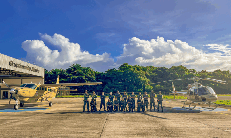 Equipe frente a aviões do Grupamento Aéreo.