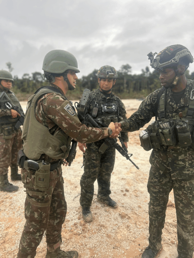 Soldados do exército cumprimentam-se em área de treinamento.