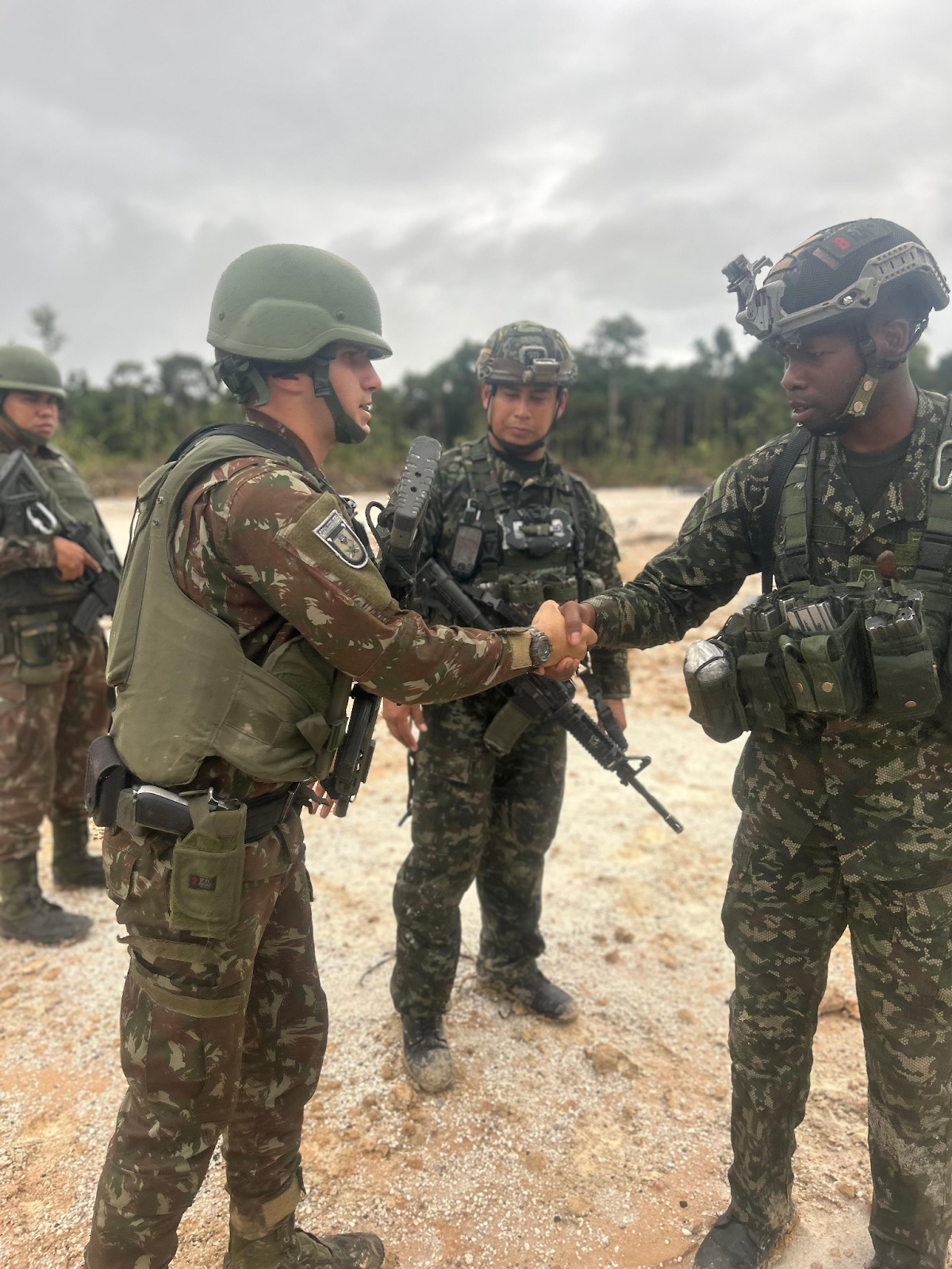 Soldados do exército cumprimentam-se em área de treinamento.