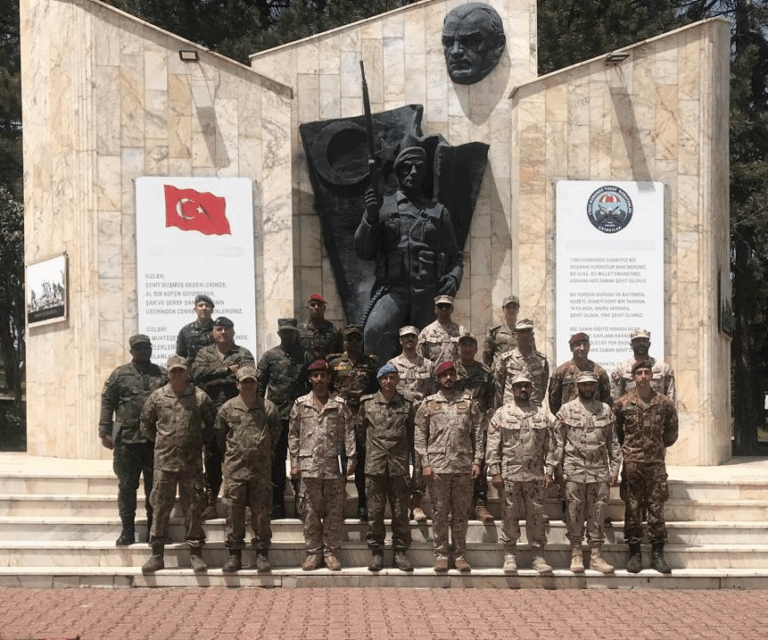 Soldados em frente a monumento militar turco.