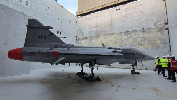 Avião de combate parado em compartimento fechado.