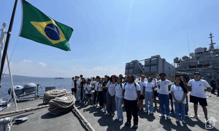 Grupo de jovens em navio com bandeira do Brasil.