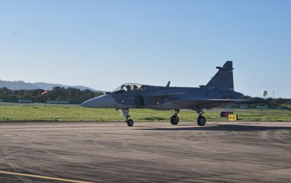 Avião de caça estacionado em pista de decolagem.