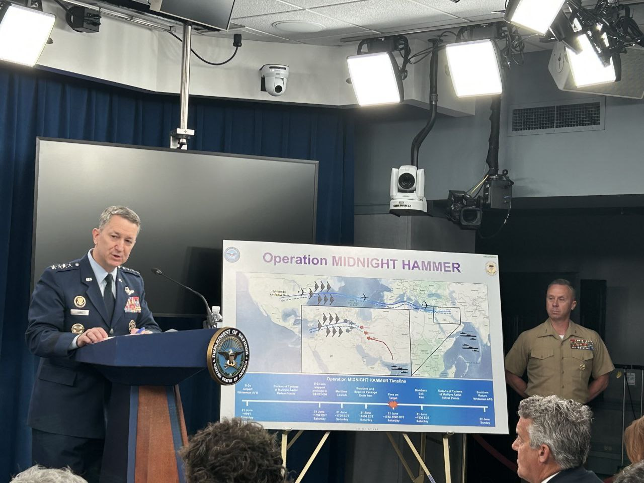 Oficial apresenta plano militar em coletiva de imprensa.