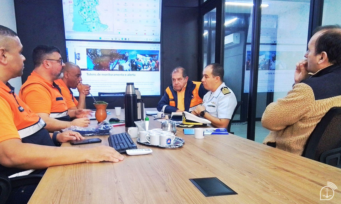 Reunião de monitoramento e alerta em sala de controle.