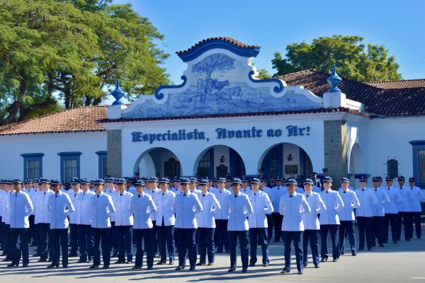 Desfile de militares em frente a edifício histórico.
