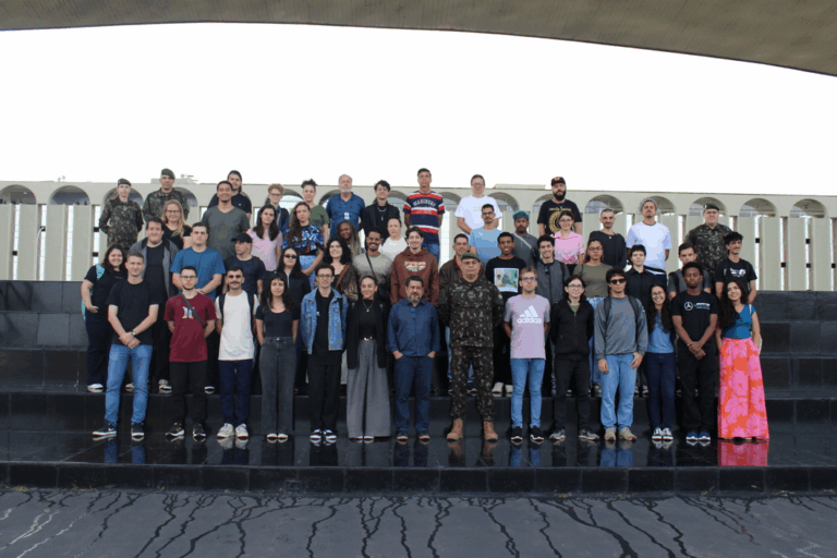Grupo de pessoas posando em escadaria ao ar livre.