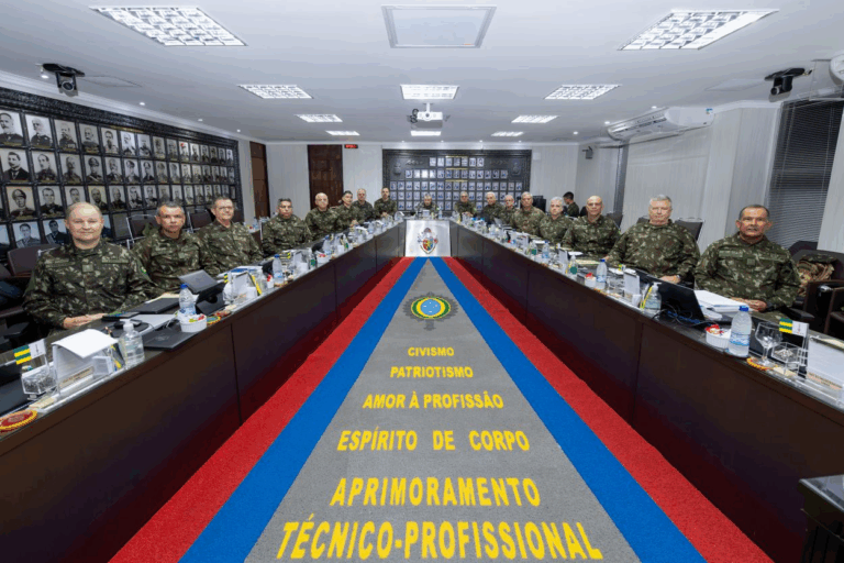 Oficiais militares em reunião em sala de conferência.