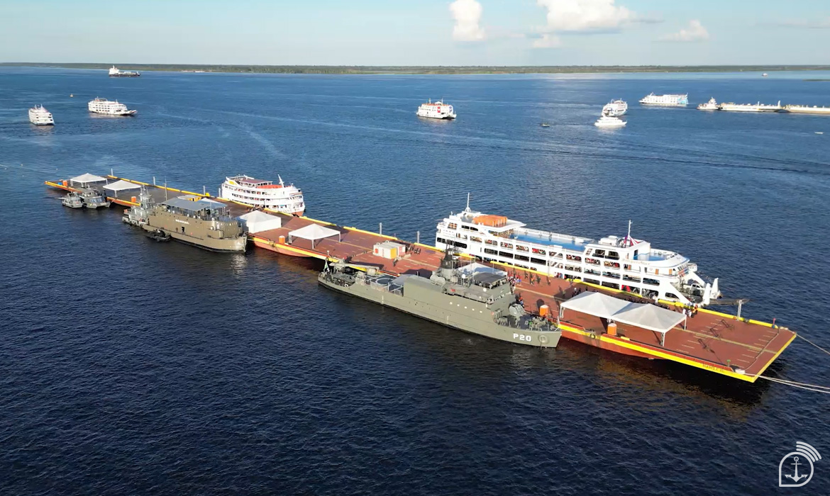Navios atracados no rio sob céu azul.
