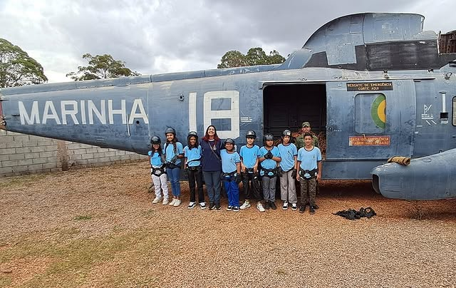 Crianças posam em frente a helicóptero da Marinha.