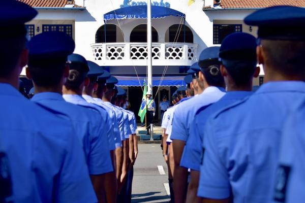Militares em formação diante de edifício oficial.