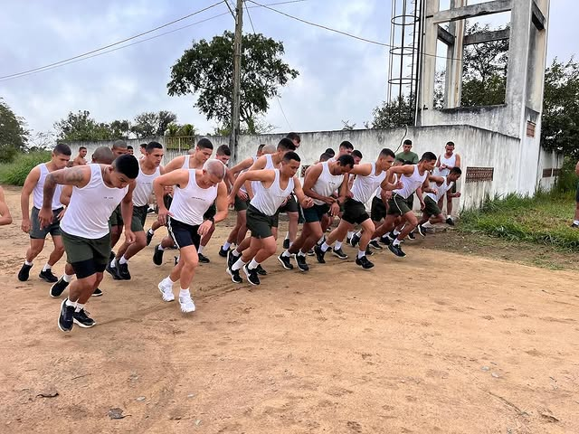 Grupo de soldados iniciando corrida ao ar livre.
