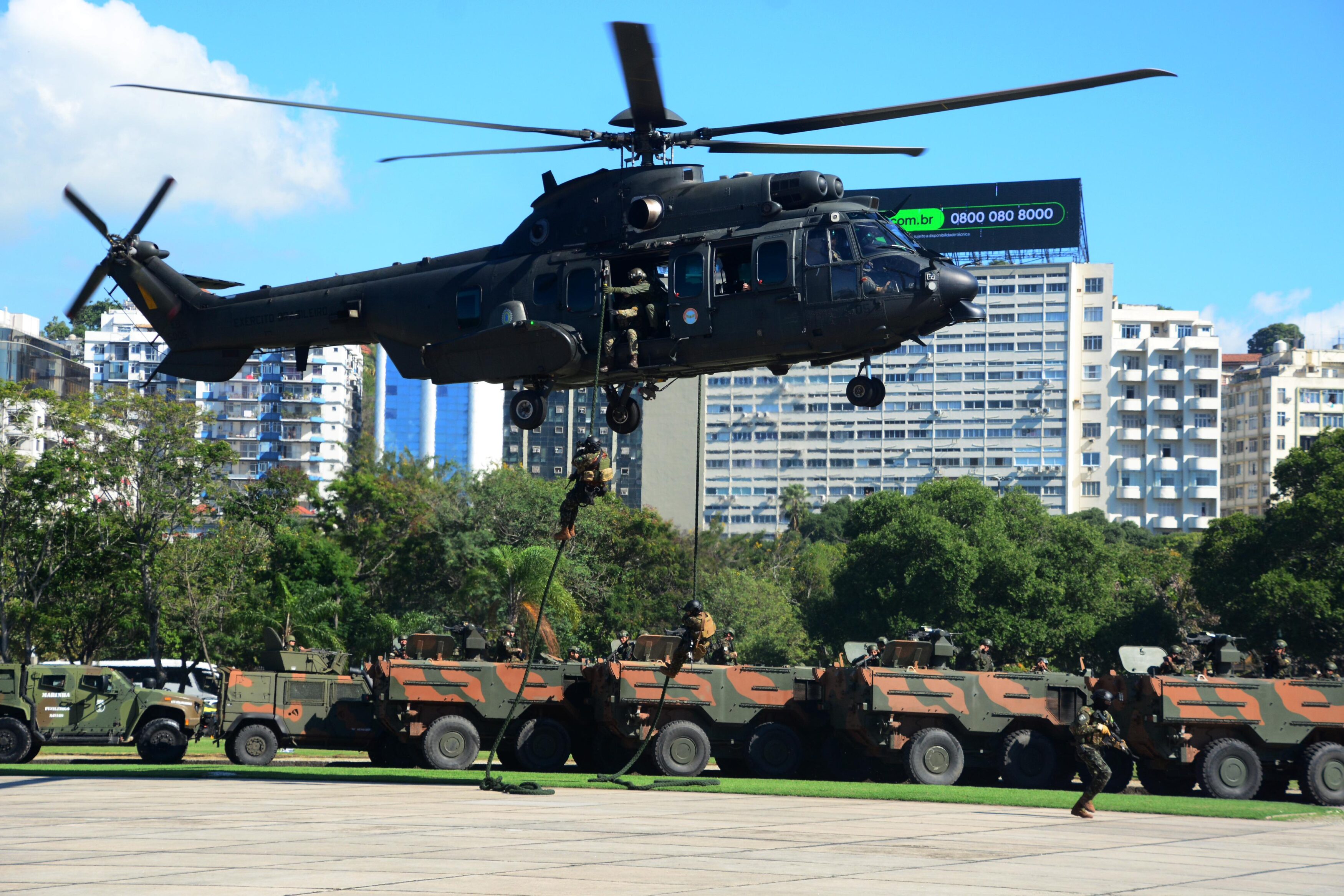Militares descem de helicóptero em treinamento urbano.