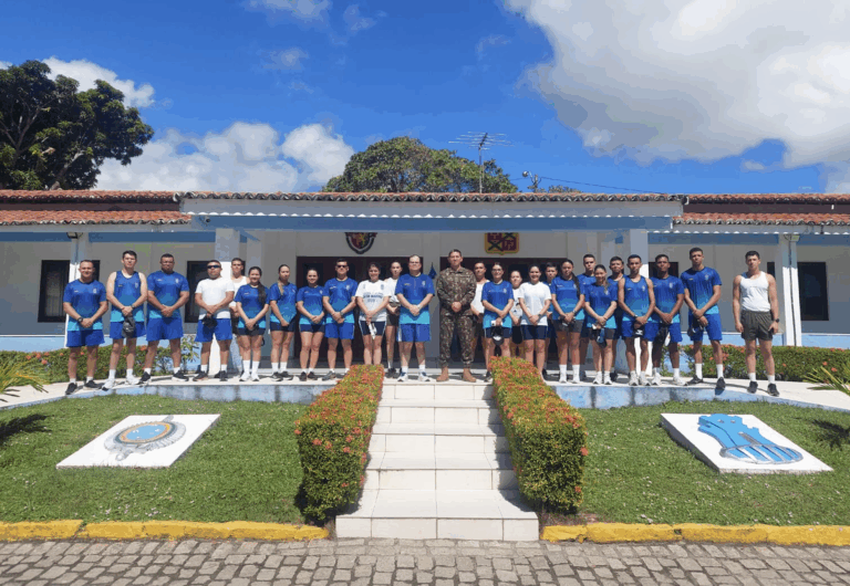 Grupo de pessoas uniformizadas em frente a prédio militar.