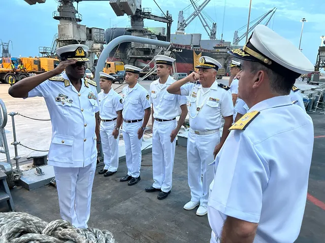 Militares saudando em um porto.