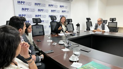 Reunião com pessoas em mesa de conferência no MPF.