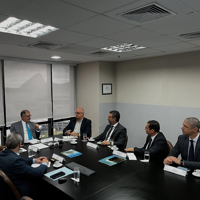 Executivos reunidos em mesa de conferência.