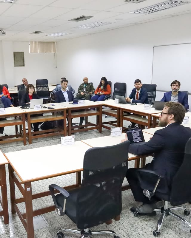 Reunião com pessoas em mesa de conferência.