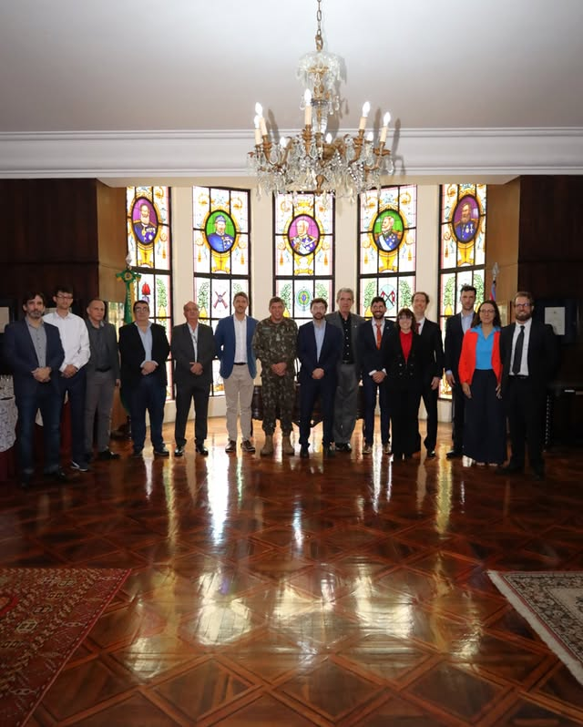 Pessoas reunidas em frente a vitrais coloridos.