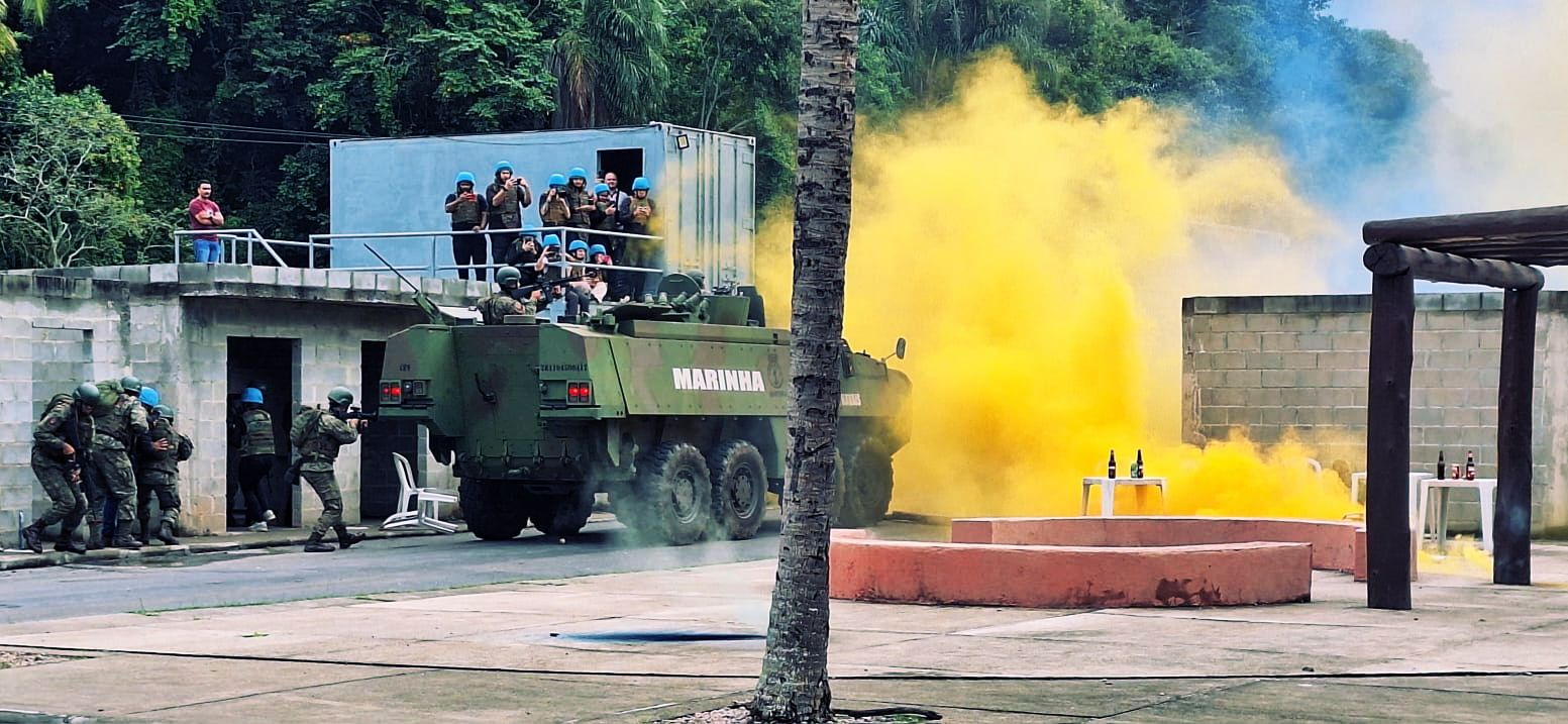 Exercício militar com veículo da Marinha e fumaça amarela.