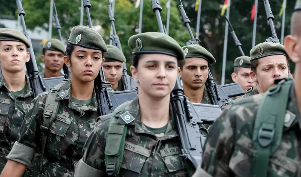 Soldados brasileiros em marcha com fardas militares.