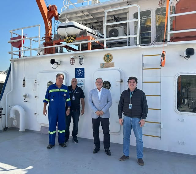 Quatro homens em um barco vestido para trabalho.