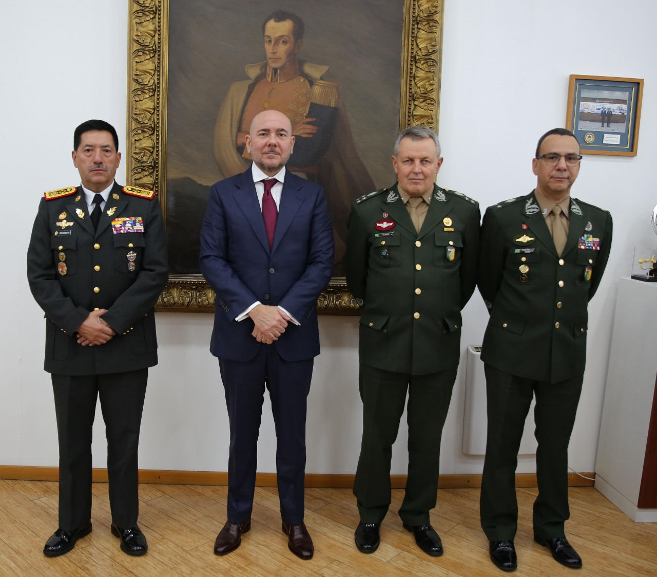 Quatro homens em uniformes militares e terno formal.