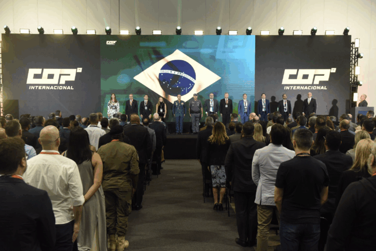 Conferência COP com bandeira do Brasil no palco.