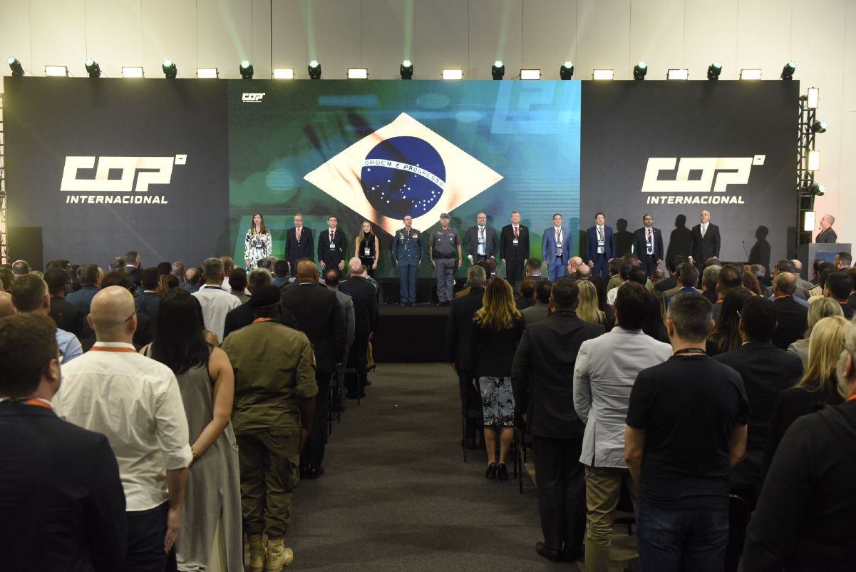 Conferência COP com bandeira do Brasil no palco.