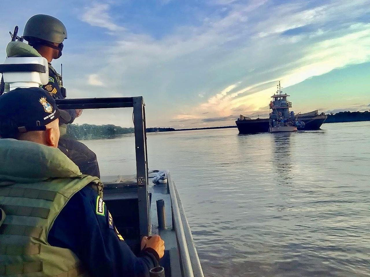 Patrulha naval em rio ao pôr do sol.