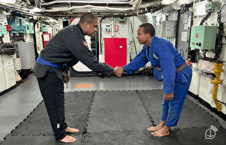 Dois homens cumprimentam-se em dojo de jiu-jitsu.