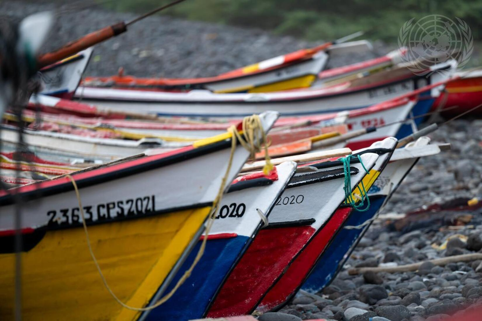Barcos coloridos sobre pedras na praia.